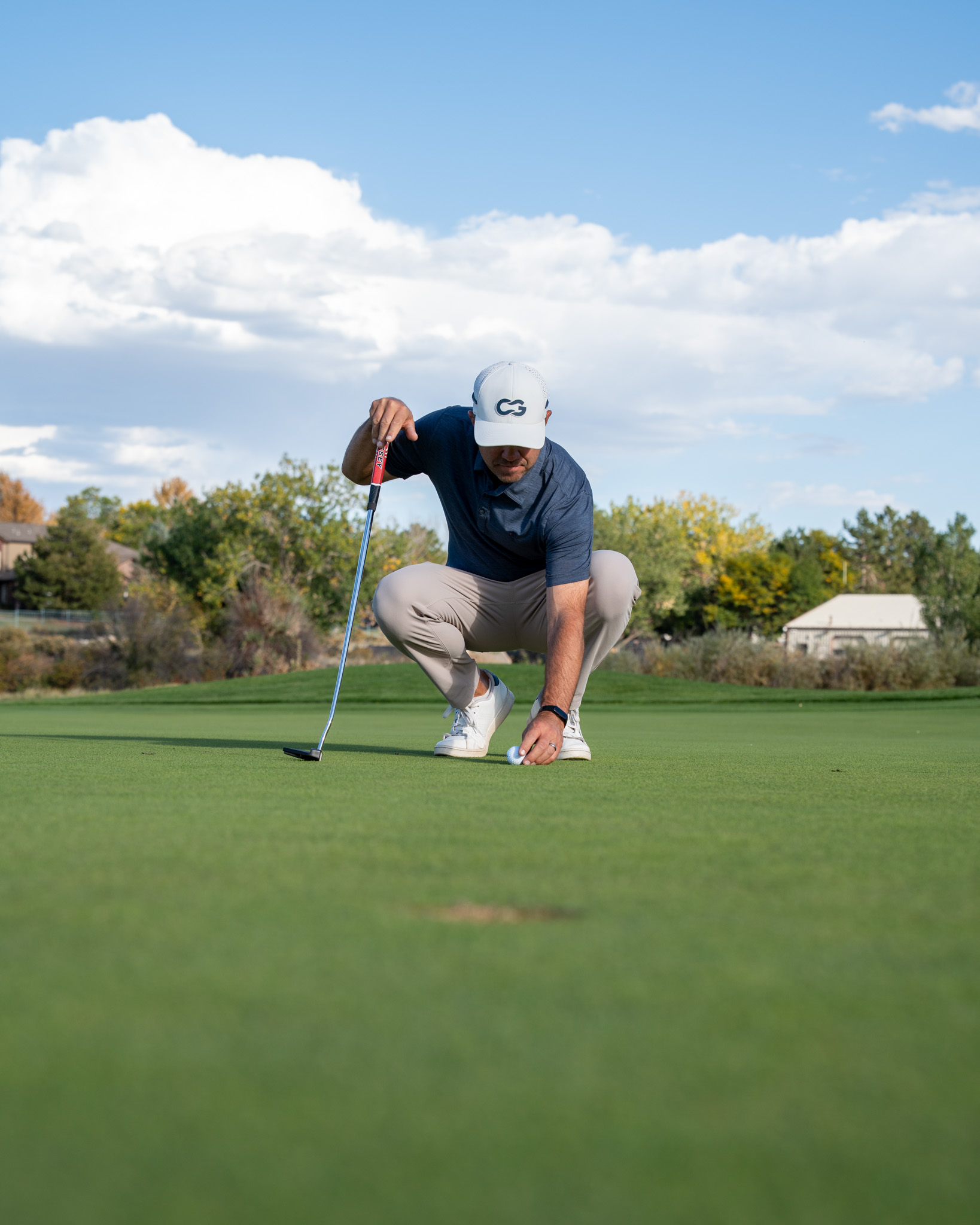 Kyle Voska setting a ball on the golf course.