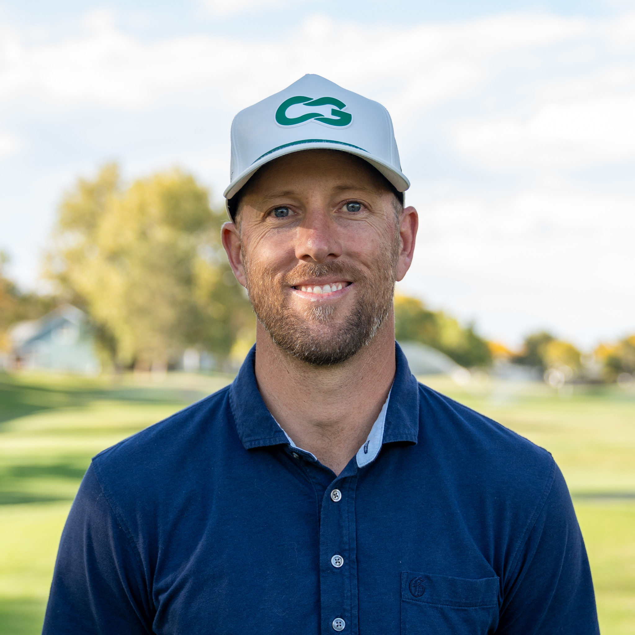 Mike Weingartner smiling and looking into the camera on a golf course.