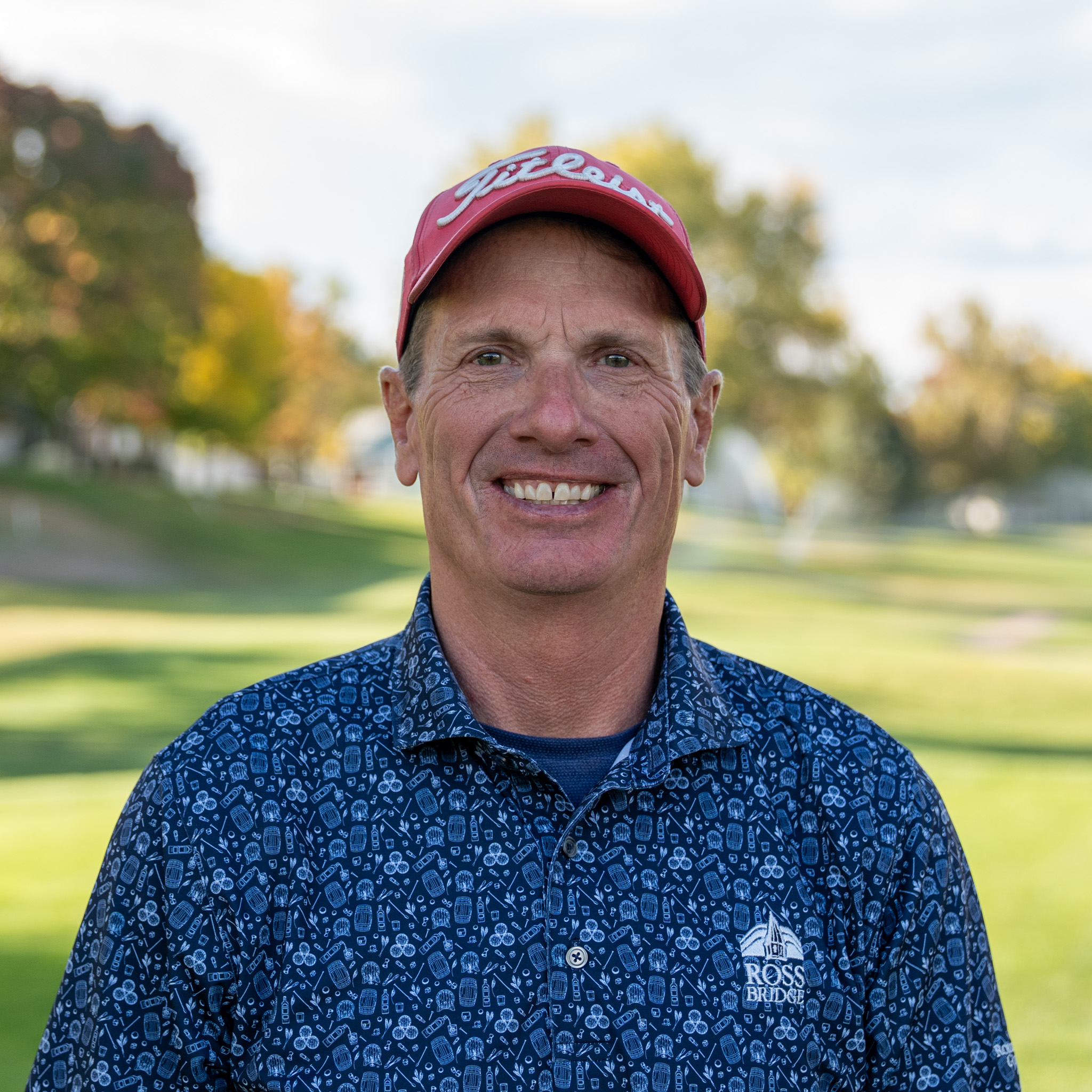 Tim Hayes smiling and looking into the camera on a golf course.
