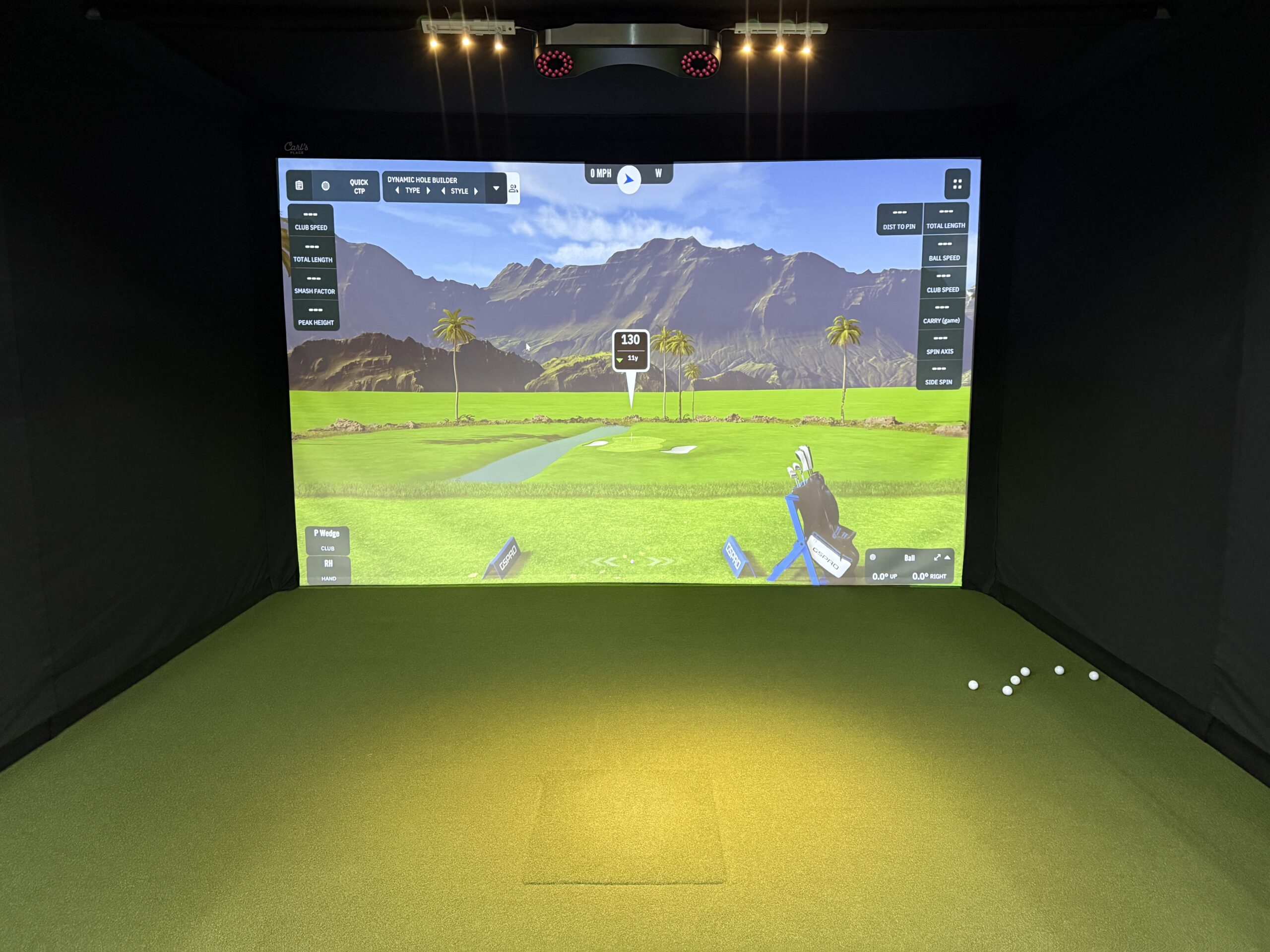 One indoor golf simulator bay with a view of a coastal golf course.